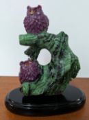 A carved crystal ruby and zoisite carved figure of owls on a tree trunk, 18k yellow gold beaks,