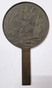 A Japanese mirror, with grass decoration to reverse.