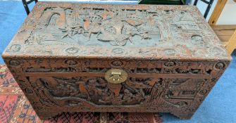 An elaborately carved camphor wood chest, with carved Chinese figures, landscapes and motifs, approx