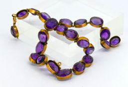 A vintage gold and 23 stone amethyst set necklace, set in 9ct gold, (droplet missing).