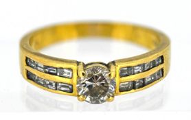 A diamond solitaire ring, set with sixteen baguette cut diamonds to the shoulders, in a channel
