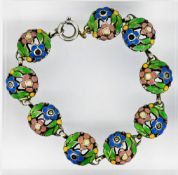 A silver and enamel floral link bracelet, with circular domed tiles/panels each with floral designs,