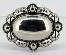 A Georg Jensen Danish sterling silver brooch with ornate decorative border with silver ball accents,