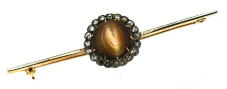A large cats eye brooch, surrounded by a halo of small diamonds, set in 9ct yellow gold, approx 4.