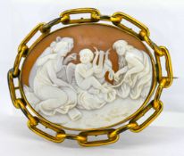 A large pinchbeck frame cameo brooch, set in gold, depicting a classical scene.