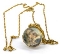 A 19th-century hand-painted miniature portrait of a young gentleman, contained in a gold and glass