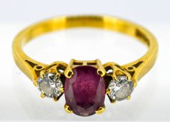 A ruby and diamond three stone set ring, set in 18ct yellow gold, size L/M.