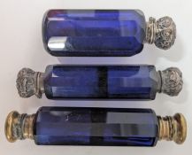 Three royal blue glass scent bottles, to include two of double ended design, white and yellow