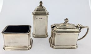 A three piece silver cruet set, to include pepper shaker, salt, and mustard pot, with blue glass