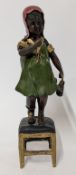 After Juan Clena (Spanish, 1875-1958), a painted bronze sculpture of a girl standing on a stool,