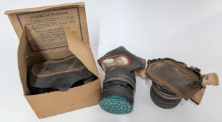 Three WWII adult gas masks, one boxed. (3)