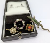 A ruby and diamond wreath design brooch, set in 9ct white gold together with other brooches.
