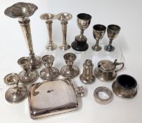A collection of silver items, to include a set of four candlesticks, spill vases, trophy cups, and