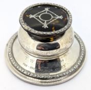 A white metal capstan inkwell, with elaborate tortoiseshell cover and embossed decoration, total