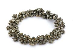 An antique paste stone flower bracelet, each articulated flowerhead and fancy inter-link set with
