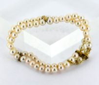 A 9ct gold double row cultured pearl necklace, pearls approx. 5.5mm, line carved spacer bars and