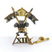 A British Army 12th Royal Lancers Regiment cap badge XII, safety chain, marked 9ct & SIL, length