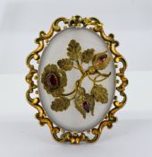 A Victorian floral brooch, the oval chalcedony plaque with a floral and foliate overlay set with