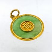 A jade pendant, of circular form with a double sided central plaque depicting Chinese characters,