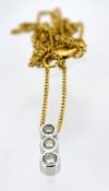 A modern diamond trilogy pendant with an 18ct gold chain, the pendant collet set with three slightly