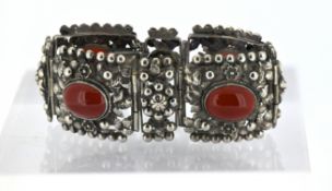 A floral and foliate panel link bracelet, four of the openwork articulated panels set with orange