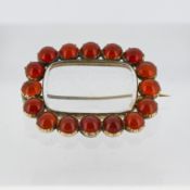 A Victorian keepsake brooch, the central hinged keepsake compartment with a surround of circular