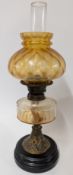 A yellow glass oil lamp with brass body on an ebonised base, height approx 57cm.