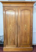 An early 20th century panelled mahogany two door wardrobe, with painted floral motifs, approx