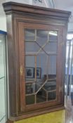 A 19th century mahogany corner cabinet, with geometric glass door, gilt lock plate and hinges,