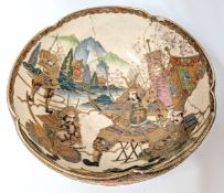A large Japanese bowl, decorated with figures and motifs picked out in gilt, on a wooden stand