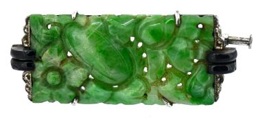 An Art Deco jade and enamel brooch, claw set with a rectangular floral carved & pierced jade plaque,