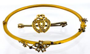 An antique pearl bangle and a brooch, the 9ct gold hinged bangle with floral & foliate decoration