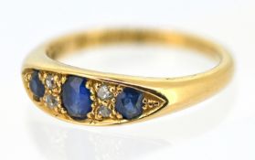 An 18ct gold sapphire and diamond ring, grain set with three oval-cut sapphires, each interspaced