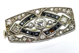 An Art Deco diamond and onyx brooch, of geometric openwork form milgrain & grain set with old-cut