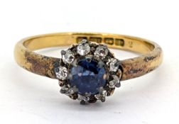 An early 20th century 18ct gold sapphire and diamond cluster ring, claw set with a circular-cut