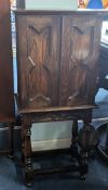 A small oak freestanding cupboard of antique design, height 97cm, width 45cm.