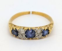 A sapphire and diamond ring, claw set with three circular-cut sapphires, each interspaced