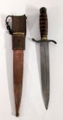 A 20th century Commando dagger with wooden hilt and a metal and leather scabbard.