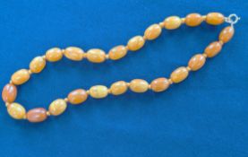 A string of butterscotch amber beads, oval beads, knotted, gold plated bolt ring