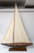 Nauticalia of Greenwich, a large model yacht, blue painted hull, on a wooden base with plaque