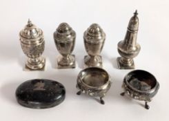 A collection of silver pedestal salt and pepper pots, and a pair of silver table salt pots