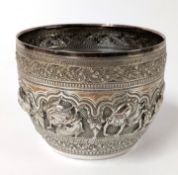 A decorative Indian silver bowl, with depictions of people, birds, and large cats