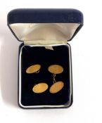 A pair of 18ct gold cufflinks with engine turned engraving, one with broken chain