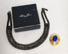 A Boucheron parfum bottle together with a beaded necklet (2).