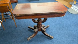 A 19th century mahogany fold over tea or card table, with carved foliate scroll motifs to base