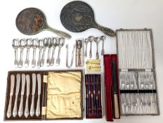 A collection of silver-plated flatware, with two mirrors.
