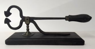 A pair of antique sugar cutters, on a base.