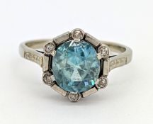 An Art Deco blue zircon and diamond target ring, claw set with a circular-cut blue zircon, the mount