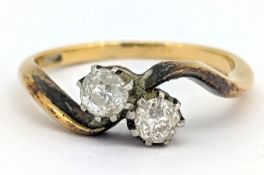 A two stone diamond twist ring, claw set with two old-cut diamonds, indistinct mark, size L1/2, 3.