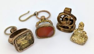 A group of four antique fobs, including a carved carnelian seal fob with an openwork fish designed
